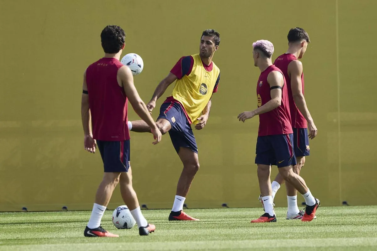 Rodrigo y Gavi juguetean con el balón sobre el césped este sábado.